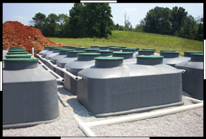 Large septic tanks installed outdoors in a rural setting.